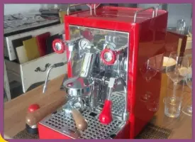 Eine rote Espressomaschine auf einem Tisch. Perfekt für die Zubereitung von köstlichem Kaffee.