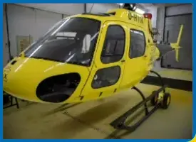 Ein gelber Hubschrauber steht in einer Garage.
